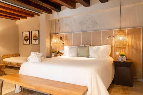 a bedroom with a large white bed and a wooden table at Hotel Casa Don Luis by Faranda Boutique, a member of Radisson Individuals in Cartagena de Indias