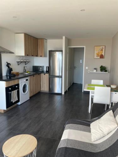 une cuisine et un salon avec un canapé et une table dans l'établissement Studio VUE MER terrasse, à La Ciotat