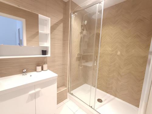a bathroom with a glass shower and a sink at Au Pied de la gare et centre ville - 2 chambres - spacieux in Amiens