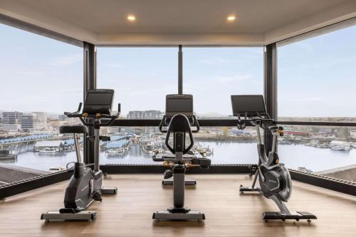 a gym with cardio equipment in a large room with large windows at Radisson Blu Vancouver Airport Hotel & Marina in Richmond