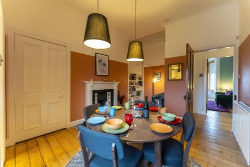 a dining room with a table and chairs and a fireplace at Ochil View in Stirling