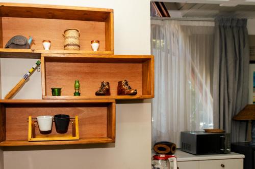 a shelf with shoes and cups on a wall at STAY In TEHAMA in Cape Town