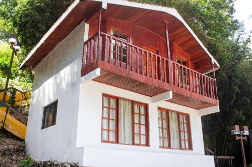 a house with a balcony on top of it at Hotel Bambito By Faranda Boutique, a member of Radisson Individuals in Cerro Punta