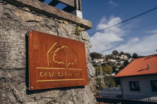 a sign on the side of a stone wall at Casa da Carvalha in Vale de Cambra