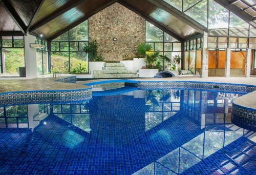 a large swimming pool with blue tiles in a building at Hotel Bambito By Faranda Boutique, a member of Radisson Individuals in Cerro Punta