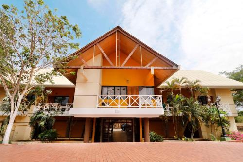 a house with a balcony and trees in front of it at Hotel Faranda Guayacanes, a member of Radisson Individuals in Chitré