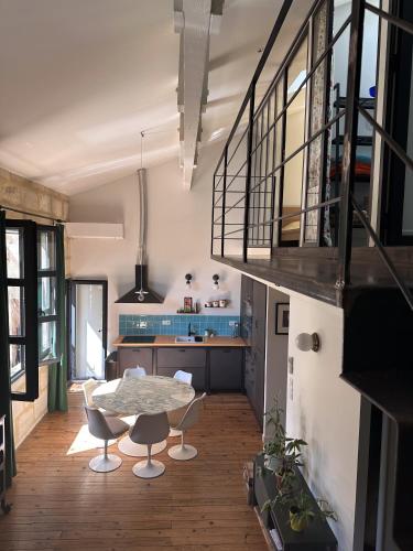 une cuisine avec une table et des chaises dans une pièce dans l'établissement Loft, à Bordeaux