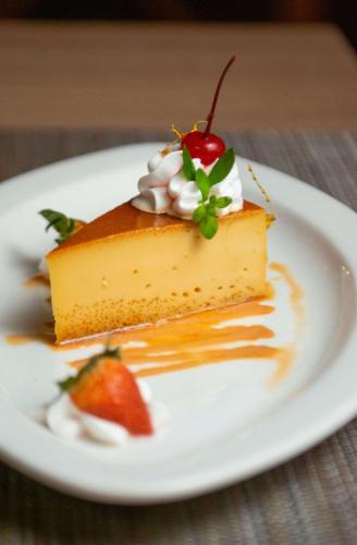 a piece of cheesecake with a strawberry on a plate at Hotel Faranda Guayacanes, a member of Radisson Individuals in Chitré