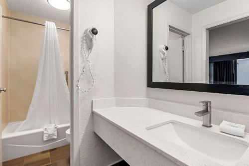 a white bathroom with a sink and a mirror at Quality Inn Slidell I-10 in Slidell