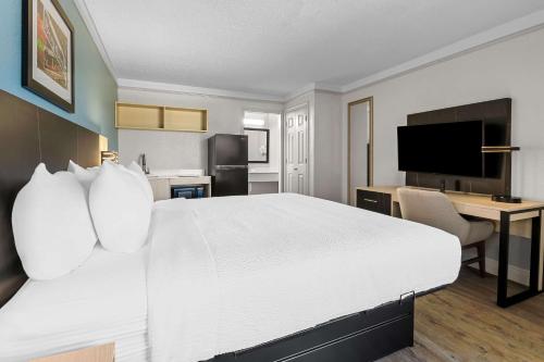 a hotel room with a large white bed and a desk at Quality Inn Slidell I-10 in Slidell