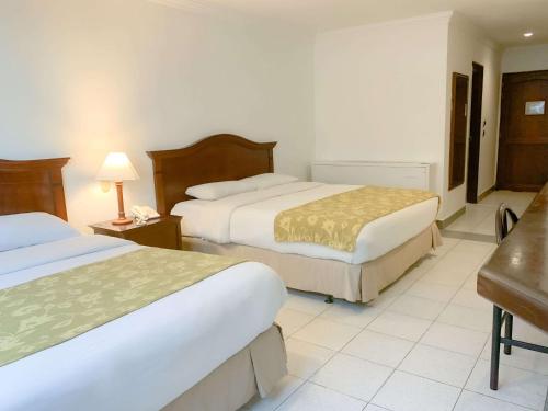 a hotel room with two beds and a desk at Hotel Faranda Express Puerta Del Sol Barranquilla, A Member of Radisson Individuals in Barranquilla