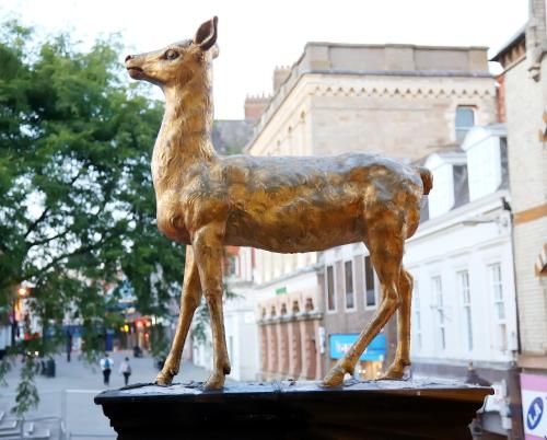 a statue of a deer standing on a ledge at The Hind Hotel in Wellingborough