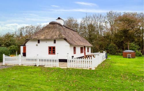 a small white house with a grass roof at Awesome Home In Tim With Wifi in Tim