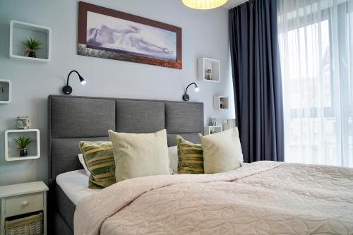 ein Schlafzimmer mit großem Bett und Fenster in der Unterkunft Horyzont by Baltic Home in Misdroy