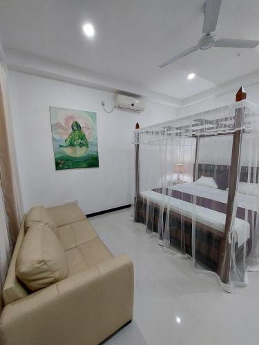 a living room with a couch and a bed at Villa Olga in Unawatuna