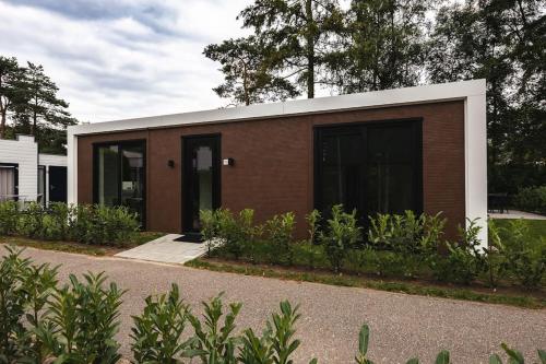 a small building with a brown and white at Tiny House 'Veluwehuisje' in Voorthuizen