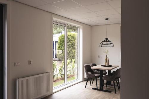 a dining room with a table and a window at Tiny House 'Veluwehuisje' in Voorthuizen