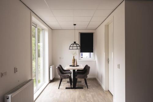 a dining room with a table and chairs at Tiny House 'Veluwehuisje' in Voorthuizen