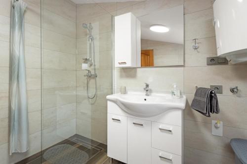 a white bathroom with a sink and a shower at Regina 1 in Banjole