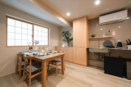 a kitchen with a wooden table with chairs and a sink at Gokan Kotohira in Kotohira