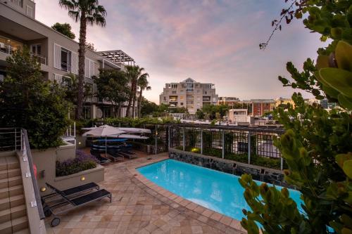a swimming pool on a balcony with a view of a city at Waterfront Village in Cape Town