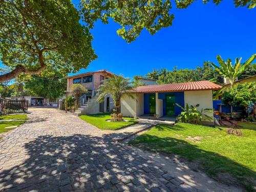 a house with a brick driveway in front of a building at Pousada Boa Sorte in Cumuruxatiba