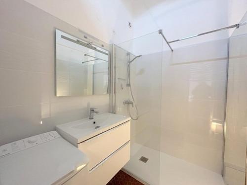 une salle de bain blanche avec un lavabo et une douche dans l'établissement Agréable maison familiale face à la mer 6LLN21, au Barcarès