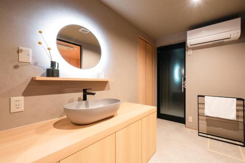 a bathroom with a bowl sink and a mirror at Gokan Kotohira in Kotohira