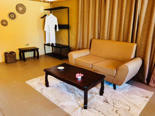a living room with a couch and a table at Mara Sweet Acacia Lodge in Talek