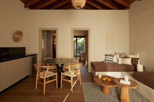 a living room with a table and chairs and a couch at Poesia Suites in Lakithra