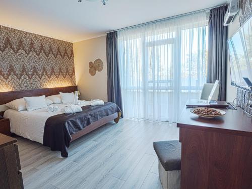 a hotel room with a bed and a desk with a computer at Holiday Beach Budapest Wellness Hotel with Sauna Park in Budapest