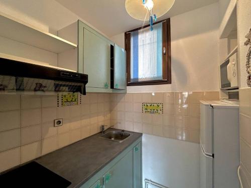 une cuisine avec un évier et un réfrigérateur dans l'établissement Agréable 3 pièces en Duplex - terrasse - parking privé - 5POPL10, au Barcarès