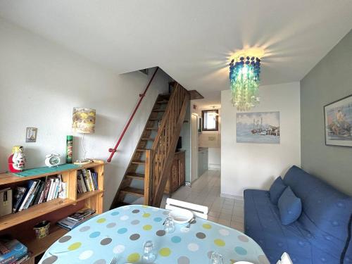 - un salon avec un canapé bleu et un escalier dans l'établissement Agréable 3 pièces en Duplex - terrasse - parking privé - 5POPL10, au Barcarès