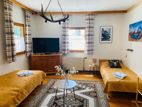 a living room with two beds and a flat screen tv at Gasthof Frasswirt in Frass