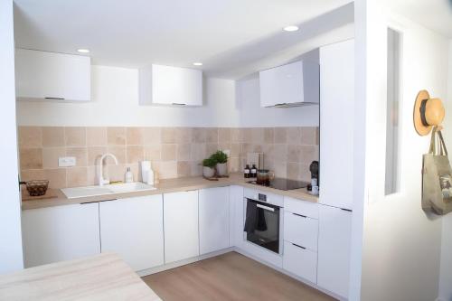 une cuisine blanche avec des armoires blanches et un évier dans l'établissement Fontenelle Appartement Calme et lumineux Rouen, Cathédrale 