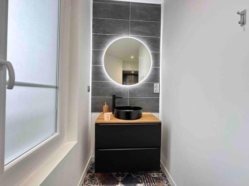 une salle de bain avec un lavabo et un miroir dans l'établissement Automne T2 neuf cosy proche centre-ville, à Reims