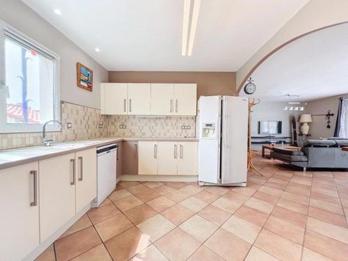 une cuisine avec des armoires blanches et un réfrigérateur blanc dans l'établissement Charmante maison à deux pas de la plage 6ALOU2, au Barcarès