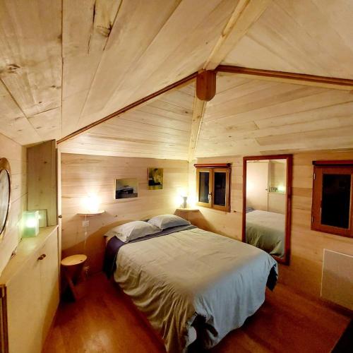 Cette chambre en bois comprend un grand lit. dans l'établissement Small duplex house in Batignolles, à Paris