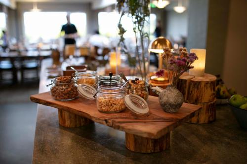 a wooden table with jars of nuts on it at Fjelsted Skov Hotel & Konference in Ejby