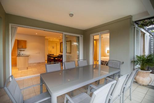 a dining room with a table and white chairs at Waterfront Village in Cape Town