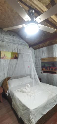 a bedroom with a bed with a mosquito net at Dreamer Resort in San Vicente