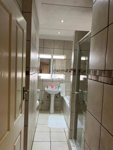 a bathroom with a sink and a mirror at Turn and slip in Bloemfontein