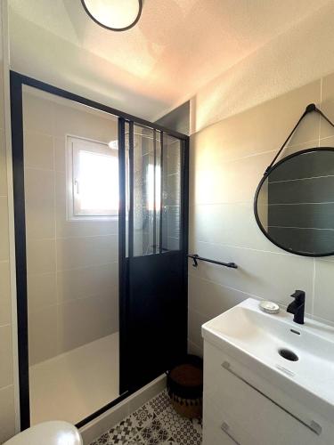 La salle de bains est pourvue d'une porte noire et d'un lavabo. dans l'établissement Charmante maison agréable pour les vacances 4BCAP64, au Barcarès