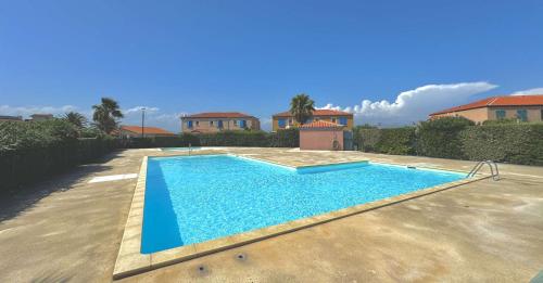 une piscine dans une cour à côté d'une maison dans l'établissement Charmante maison agréable pour les vacances 4BCAP64, au Barcarès