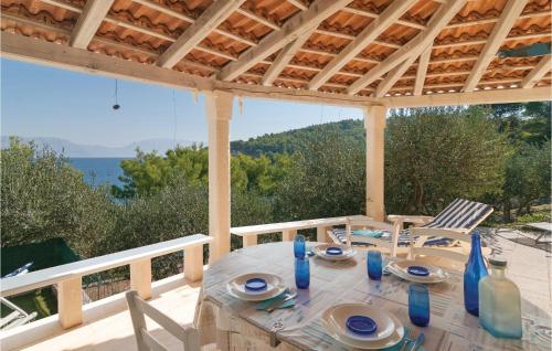a table on a porch with a view of the ocean at Two-Bedroom Holiday Home In Postira in Postira