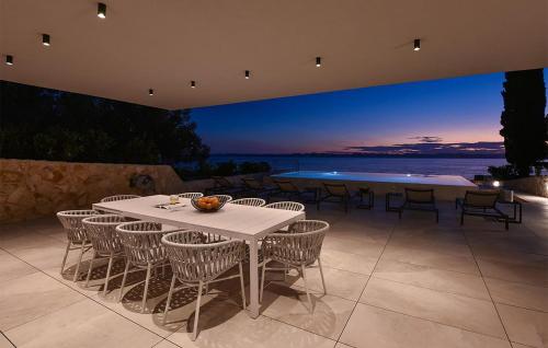 a table and chairs on a patio with a view of the ocean at Awesome Home In Zdrelac in Ždrelac