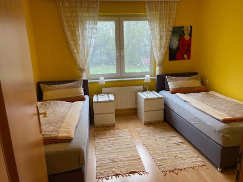 Un dormitorio pequeño con dos camas y una ventana. en Ferienwohnung Ingrid Rautenberg, en Krautheim