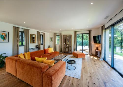 a living room with orange couches and a television at Villa Ramatuelle in Ramatuelle