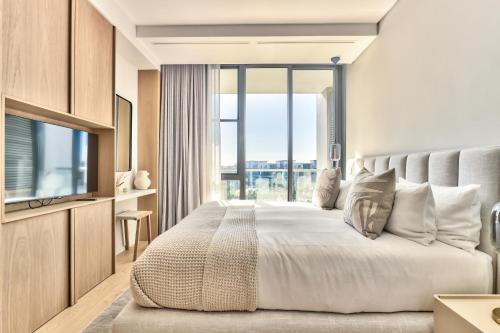 a bedroom with a large bed with a large window at Waterfront Village in Cape Town