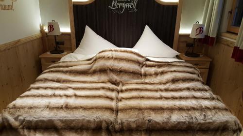 a bed with a blanket on top of it at Luxus Chalet Bischofer- Bergwelt in Alpbach